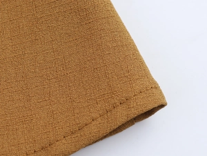 Gros plan du tissu texturé jaune gingembre avec coutures soignées et détails tissés
