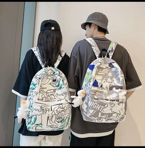 Detail of graffiti print waterproof backpack with cute white duck pendant and charms