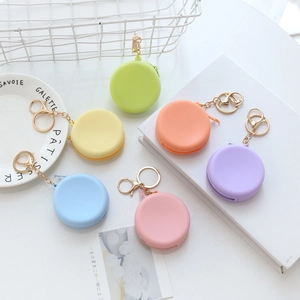 Flat lay of colorful silicone macaron mini coin purses with gold keychains in six pastel tones