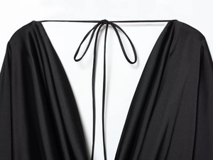 Détail du satin noir avec décolleté drapé élégant et texture soyeuse de haute qualité