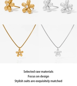Close-up of floral jewelry set featuring gold and silver flower pendants and earrings