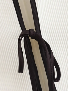 Close-up of pleated white fabric texture with black binding and tie-up drawstring detail