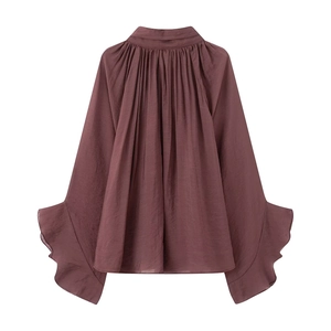 Detail of smocked high neck and layered ruffle sleeves on dark mauve sheer top