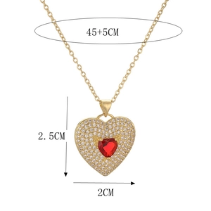 Macro detail of gold heart necklace with red gem and dimensions 2.5x2cm on O-chain