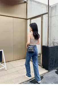 Chic quilted mini bucket bag with pearl handle and golden chain on casual denim look