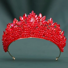 Detail einer Brautkrone mit roten Kristallen und goldenem blattförmigem Metallrahmen