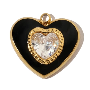 Macro view of a gold-bordered black enamel heart pendant with a white zircon center