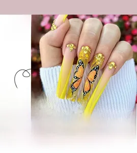Detail of yellow French press-on nails featuring black butterfly patterns and rhinestones