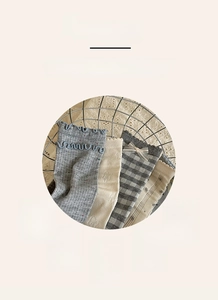 Detail of light blue and grey bow socks with lace ruffles in a decorative iron basket