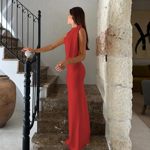 Detail of red one-shoulder maxi dress on stone stairs showing the sleek sleeveless fit