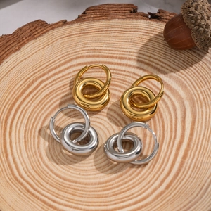 Minimalist double hoop stainless steel earrings in gold and silver finish on wood