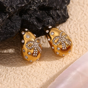 Macro shot of 18K gold plated teardrop stud earrings with diamond pavé butterfly detail