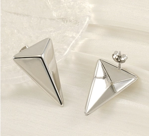 Macro detail of geometric triangle stud earrings with polished silver stainless steel finish