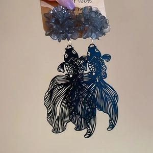 Detail of goldfish drop earring with resin flowers and laser-cut hollow metal design