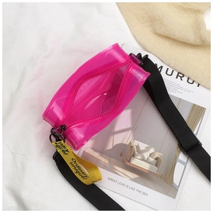 Detailed top view of pink transparent PVC crossbody bag with yellow branded strap on white fabric