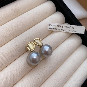 Detailed close-up of French vintage grey pearl earrings with gold-plated irregular studs