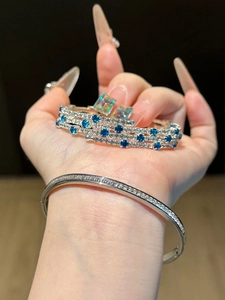 Close-up of sparkling zircon geometric layered bracelet and blue crystal jewelry set