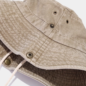 Macro detail of khaki washed canvas bucket hat with metal eyelets and adjustable side snap