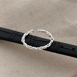 Detailed close-up of S925 sterling silver knotted braid ring on black leather strap