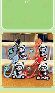 Dettaglio di portachiavi panda su moto in quattro colori con cinturini da polso abbinati
