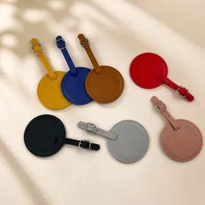 Vue à plat d'un ensemble d'étiquettes de bagages rondes en similicuir sur un bureau moderne