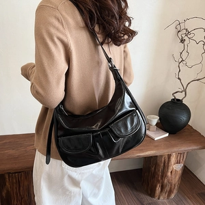 Black glossy patent leather half-moon shoulder bag with dual front flap pockets for women