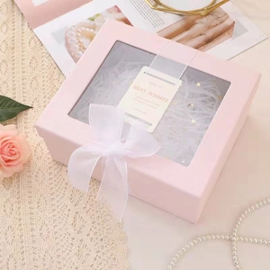 Elegant pink window gift box with white ribbon bow and shredded paper filler decor
