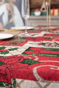 Close-up of festive jacquard woven table runner with red poinsettia and holly leaf patterns
