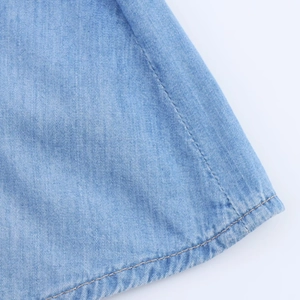 Vue détaillée de l'ourlet de la combinaison en jean avec double couture et lavage bleu clair