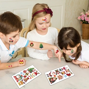 Three children wearing colorful Christmas temporary tattoos featuring Santa and reindeer