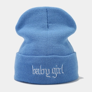 Detail der weißen Baby Girl Stickerei auf der himmelblauen Strickmütze für Damen