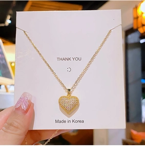 Detailed close-up of gold heart pendant necklace with shimmering paved crystals