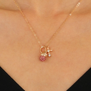 Exquisite goldene Kiefernzapfen Kreuz Halskette mit rosa Kristallen an weiblichem Model