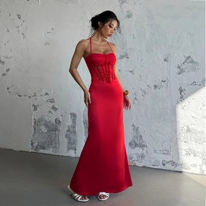 Detail of red satin backless dress featuring a lace-up corset and fishtail hem