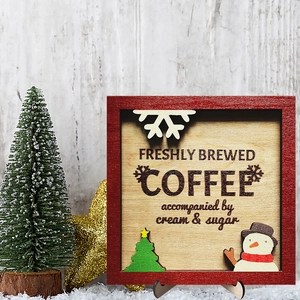 Festive wooden coffee sign with snowflake and tree motifs in a cozy holiday setting