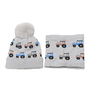 Detailed knit texture of kids' grey winter hat and scarf set with truck patterns