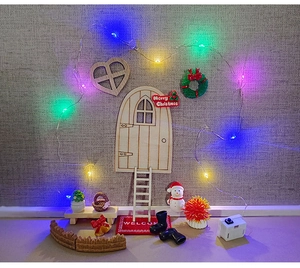 Miniature Christmas dollhouse set with wooden elf door, snowman, and glowing LED lights