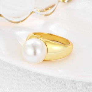 Minimalist gold ring with large round white pearl on elegant white textured background