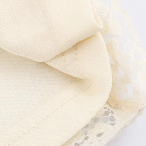 Detailopname van beige gebreide jurk met fijn kant en nauwkeurige dubbele stiksels