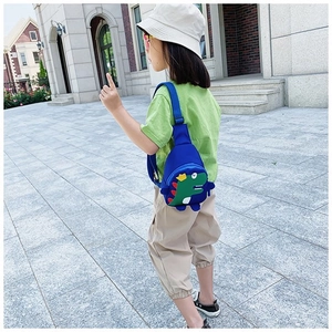 Detail of cute blue dinosaur chest bag for kids with adjustable strap and cartoon design