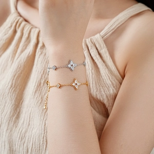 Close-up of gold and silver plated flower bracelets with cubic zirconia on female wrist