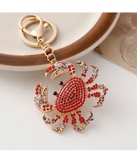 Macro detail of a golden crab keychain featuring sparkling red and multicolor rhinestones