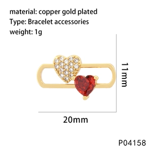 Detailed view of heart-shaped gold plated copper charm with red and clear zircon stones