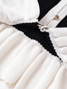 Close-up of contrast knit texture and gold button detail on an elegant white jacket