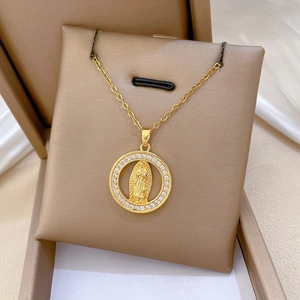 Close-up of golden Virgin Mary pendant with sparkling zirconia on brown jewelry box