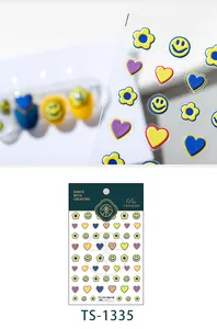 Macro detail of 3D embossed nail stickers featuring colorful smileys and floral designs
