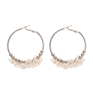 Créoles argentées avec fleurs en acrylique blanc et perles métalliques au style épuré
