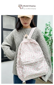 Outdoor model display of a white floral canvas backpack with sweet pastoral style details