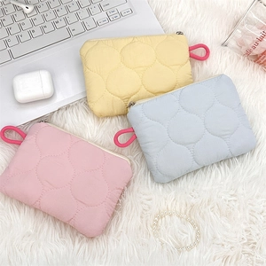 Detailed view of quilted mini storage bags in pastel yellow, blue, and pink colors