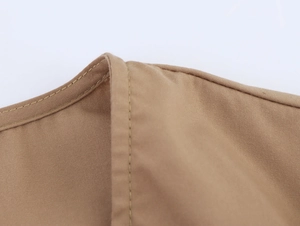 Detailed macro view of khaki cotton dress stitching and fine fabric texture quality